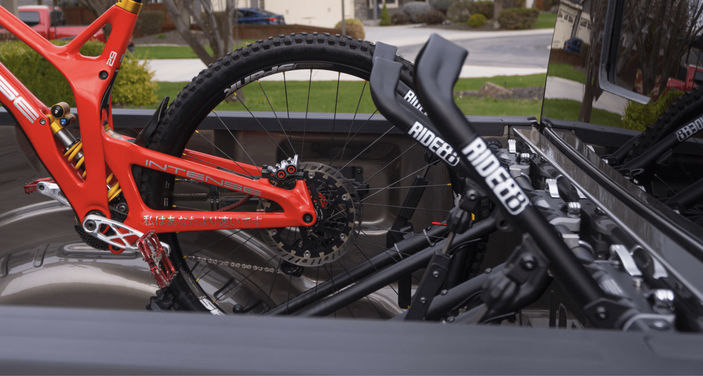 Two RIDE88 QR3 Bike Racks in a truck bed, one holding a mountain bike.