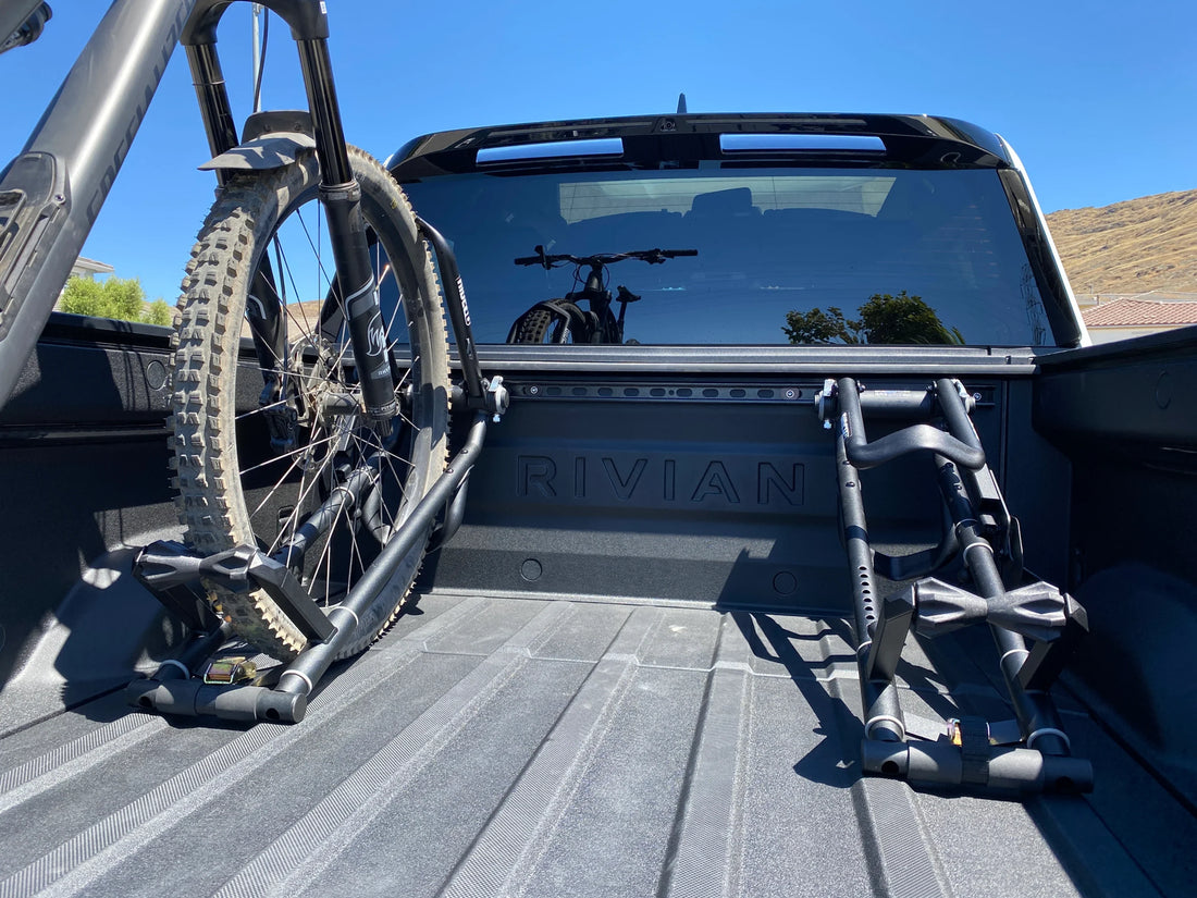 Two RIDE88 QR3 Bike Racks in the bed of a Rivian R1T, one holding a bike.