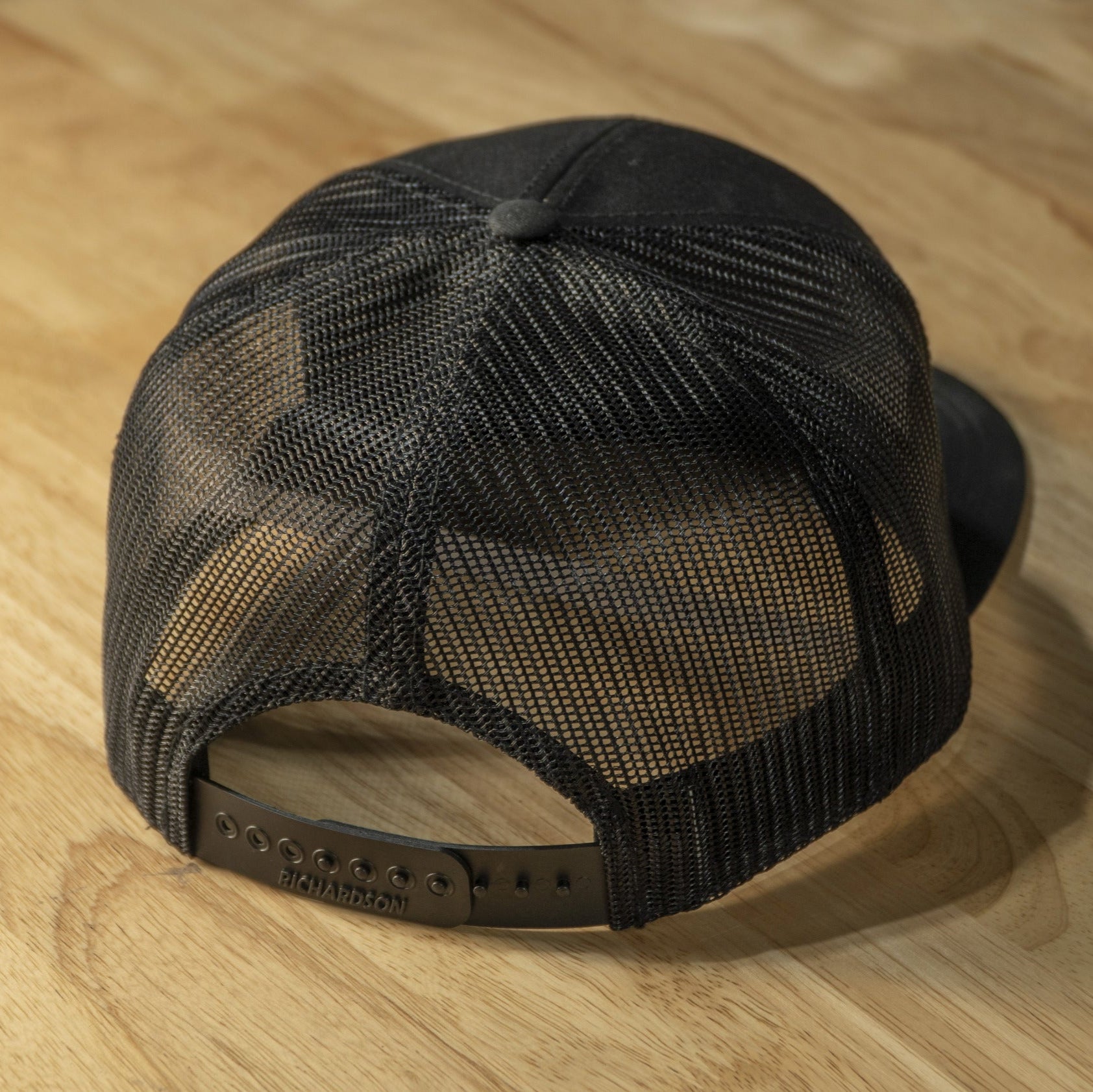 RIDE88 black trucker hat with brown leather patch logo reading “RIDE88 Ultimate Truck Bike Racks,” featuring flat bill and mesh back design.