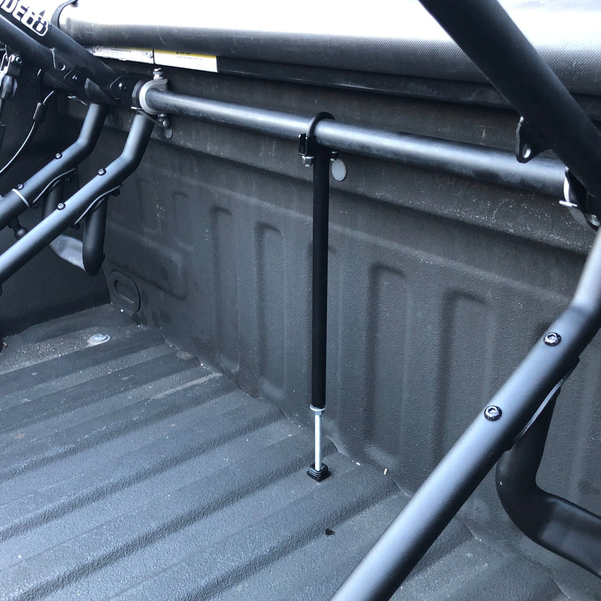 RIDE88 Center Support mounted to a crossbar in a truck bed with QR3 truck bed bike racks on either side.