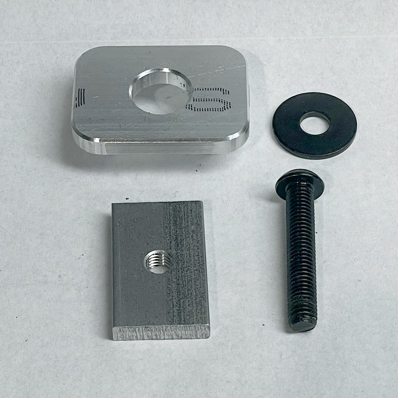 Custom aluminum insert and nut with a black bolt and washer, used for mounting RIDE88 utility track to a Chevy or GMC truck bed.