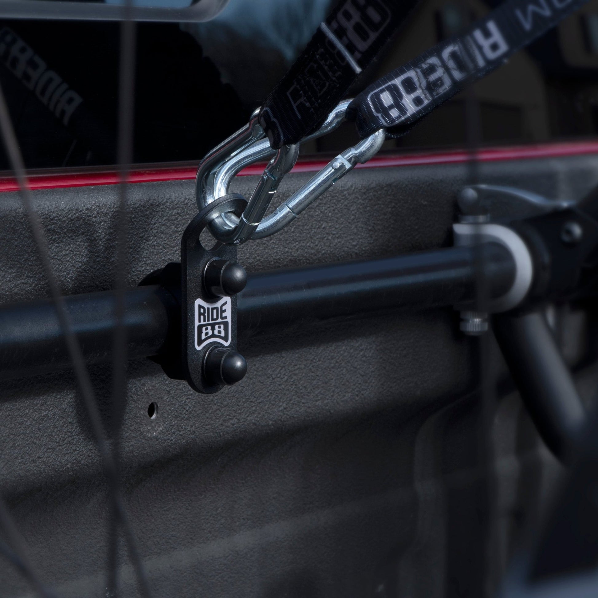 RIDE88 Crossbar Tie-Down Anchor mounted to a crossbar and holding two tie-down straps.