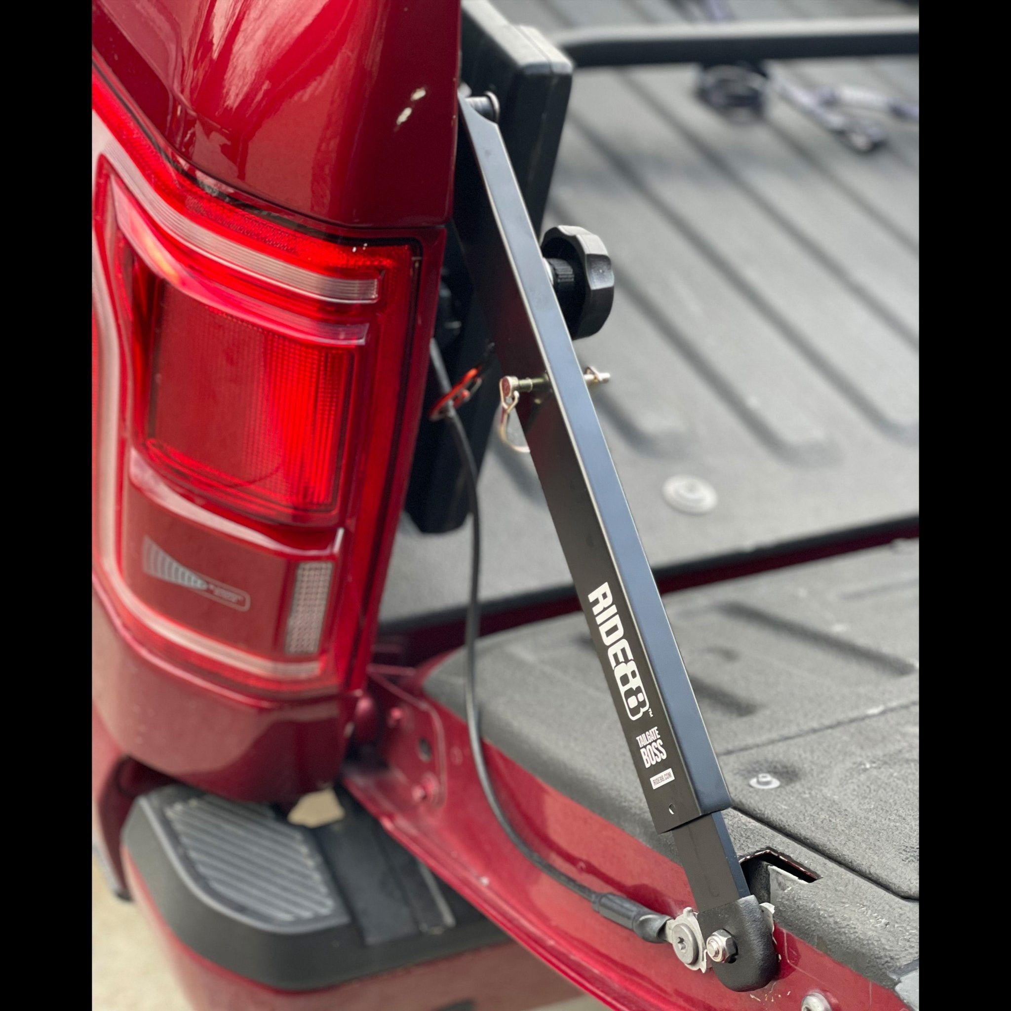 RIDE88 Tailgate Boss Pro-Kit truck bed support bar mounted on a red pickup, securing tailgate from bouncing and holding it at a closed angle.