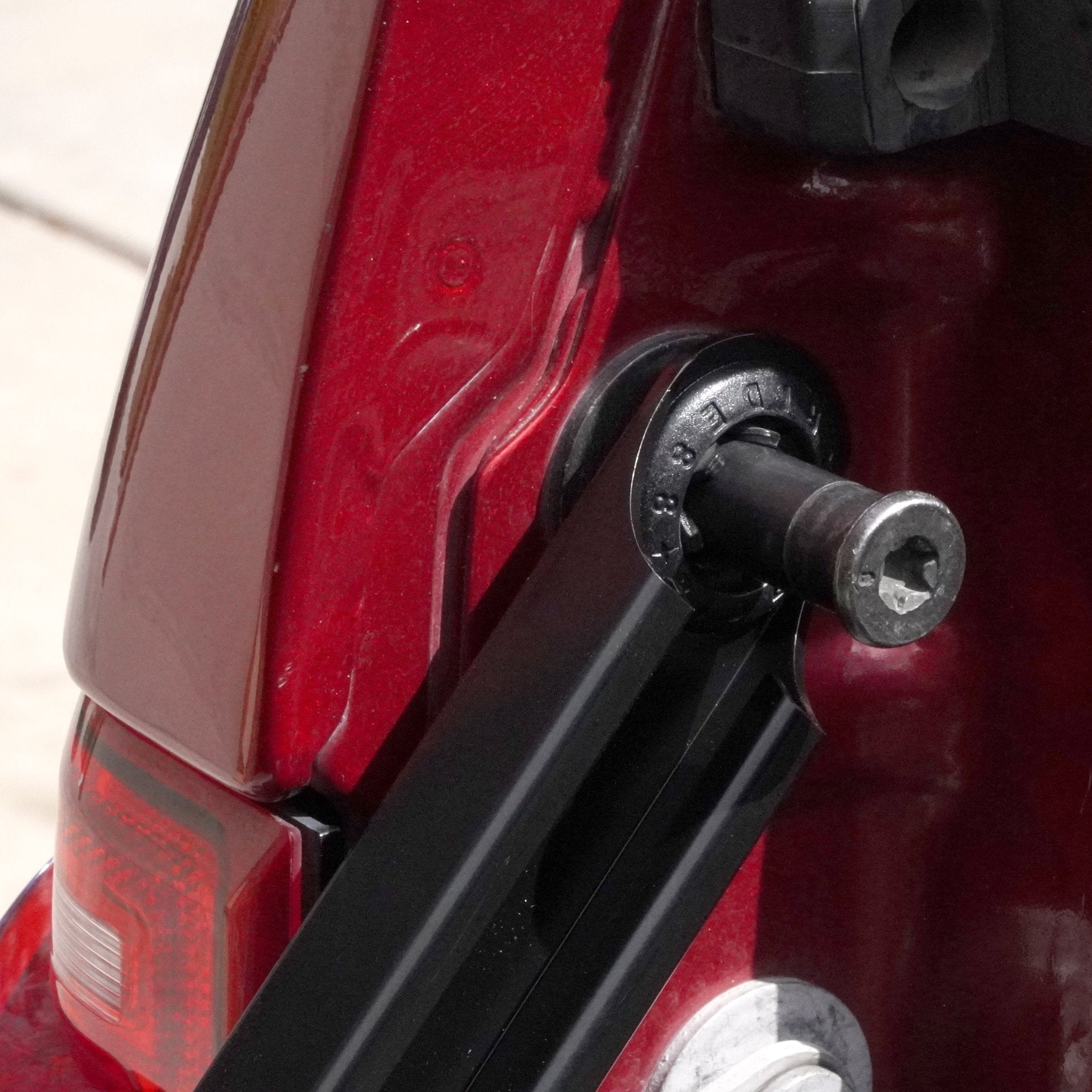 Close up of the RIDE88 Tailgate Boss tailgate support bar attached to a post and latch style striker.