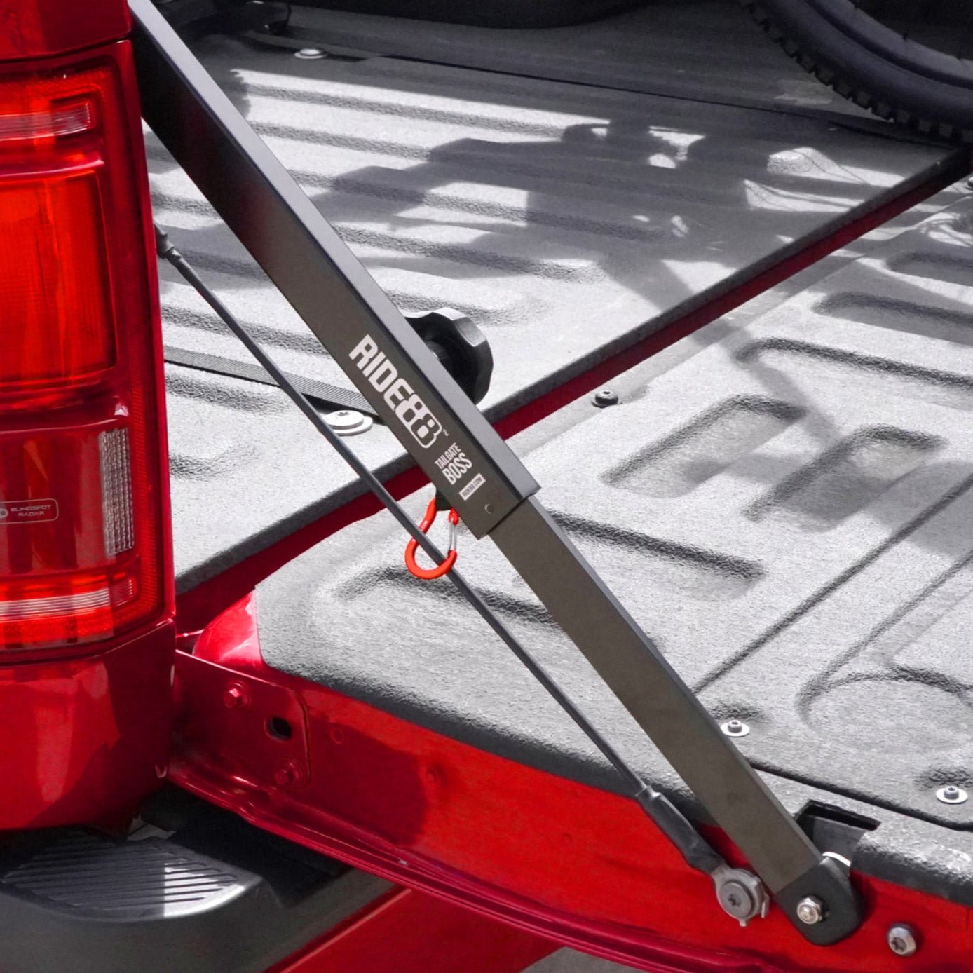 RIDE88 Tailgate Boss truck bed support bar mounted on a red pickup, securing tailgate from bouncing.