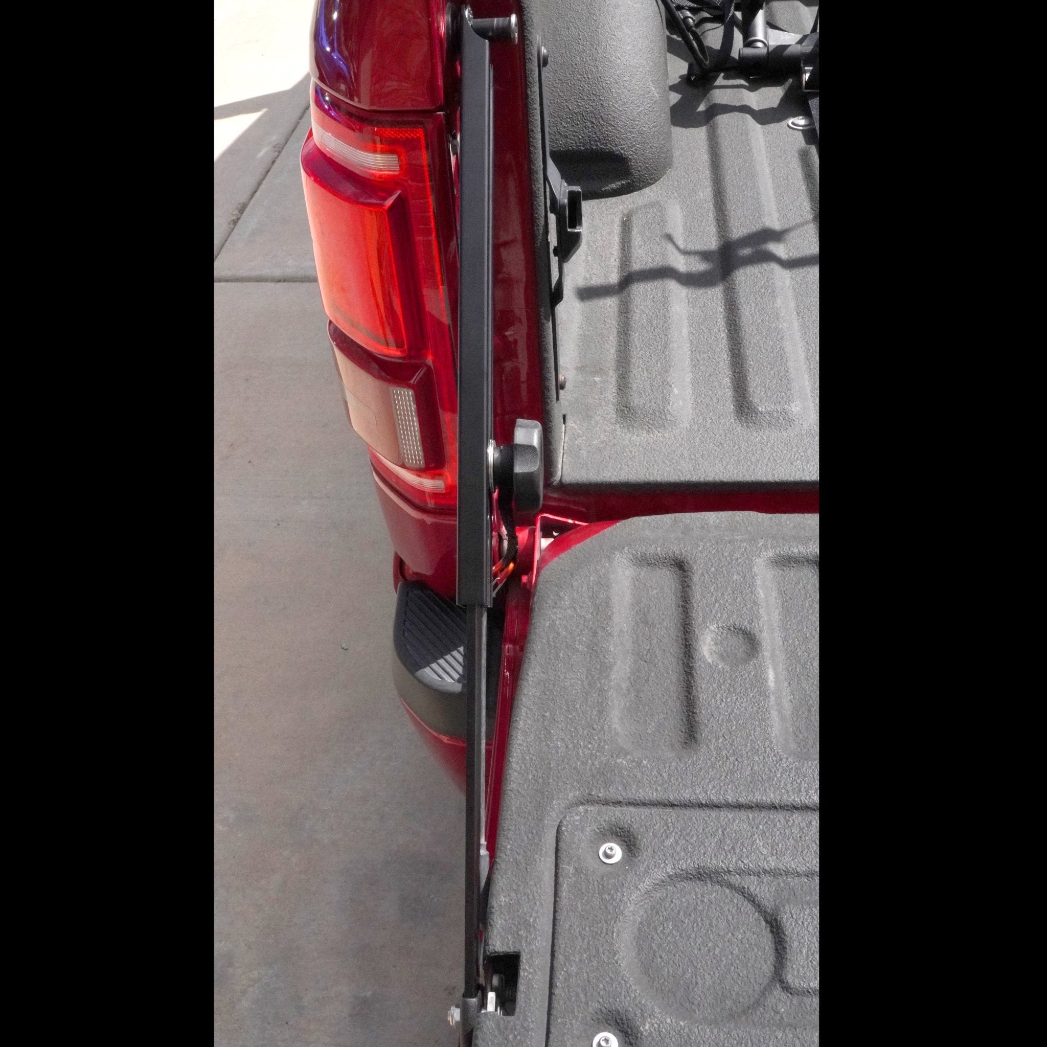 RIDE88 Tailgate Boss truck bed support bar mounted on a red pickup, securing tailgate from bouncing.