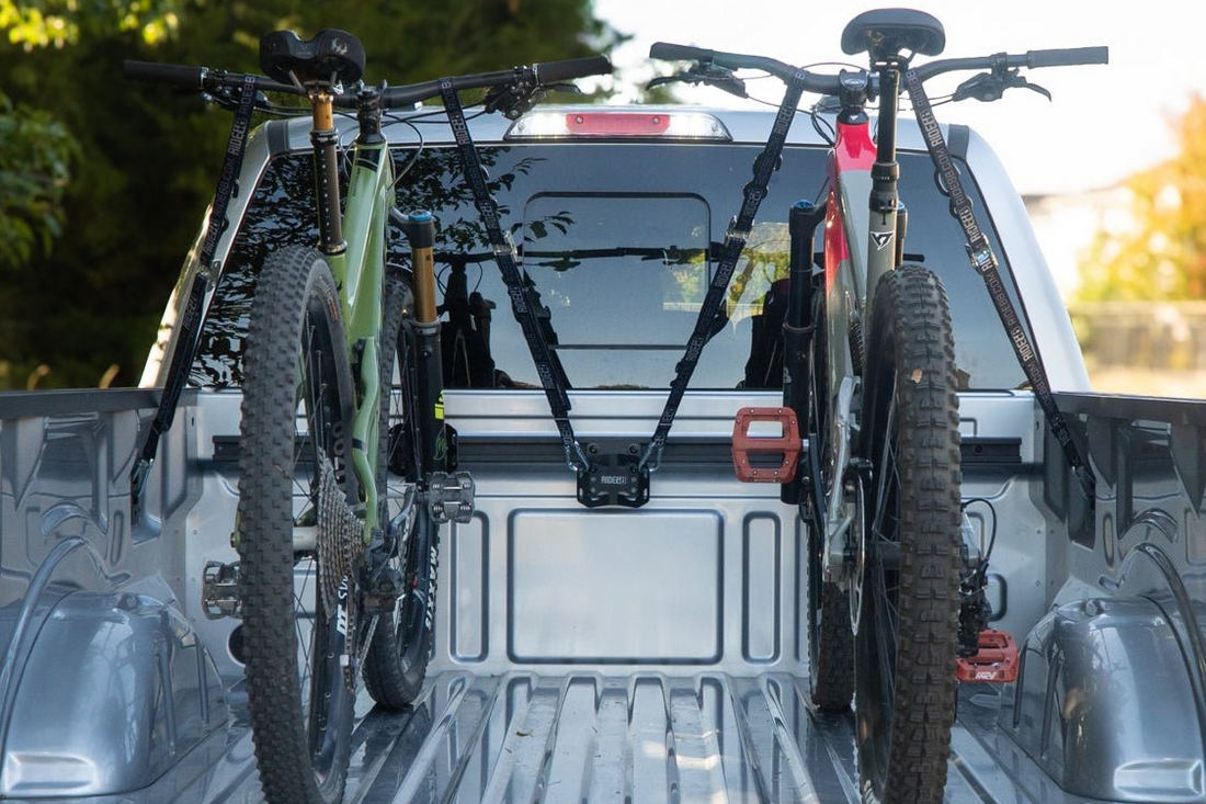 Two bikes mounted in a pickup truck bed with RIDE88 Cinch truck bed rail mounted bike racks.